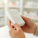 Tangan sedang membaca label pada kemasan obat di dekat meja apotek